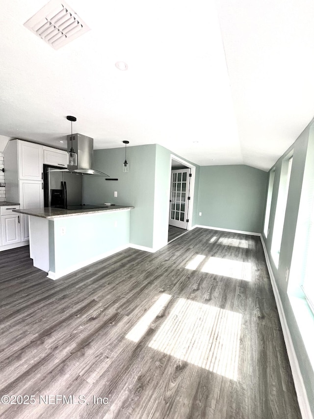 unfurnished living room with dark hardwood / wood-style flooring and vaulted ceiling