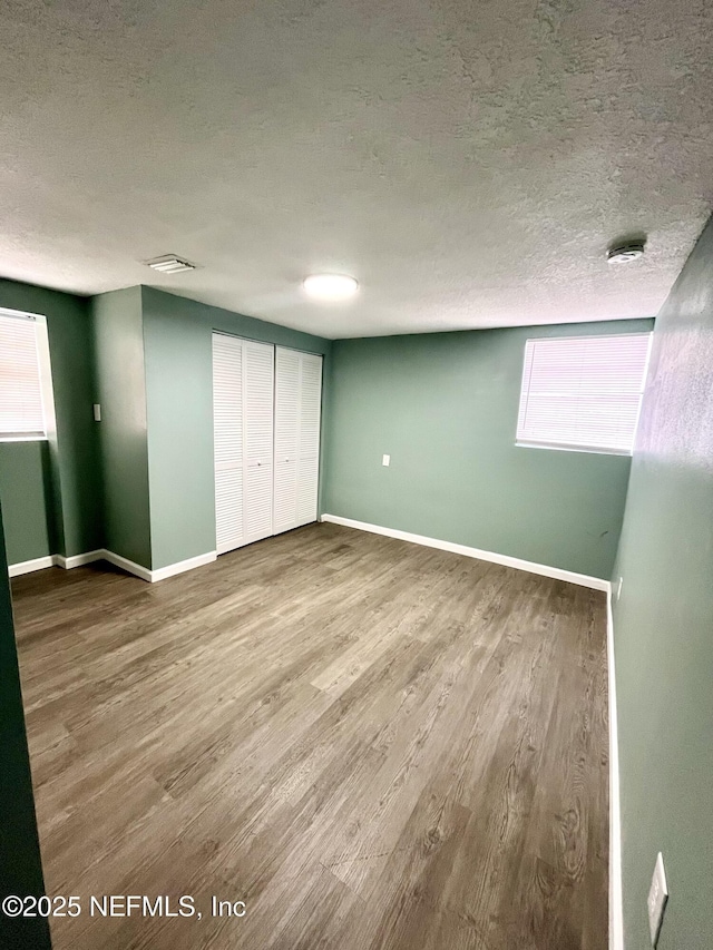 unfurnished bedroom featuring hardwood / wood-style floors and a textured ceiling