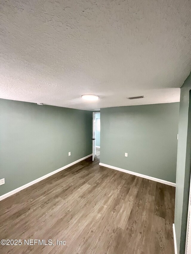 basement featuring hardwood / wood-style floors and a textured ceiling