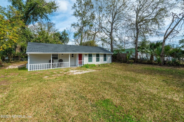 view of front facade featuring a front yard, roof with shingles, and fence