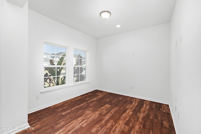 spare room featuring recessed lighting, baseboards, and wood finished floors