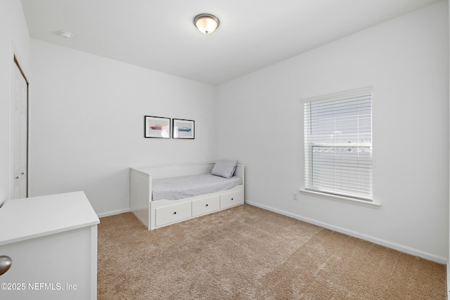 unfurnished bedroom featuring light colored carpet and baseboards