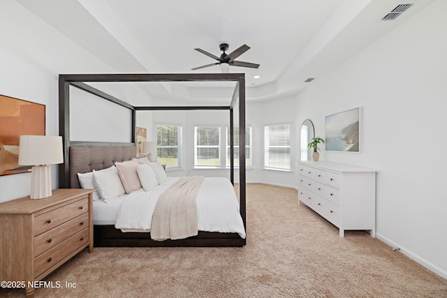 carpeted bedroom with visible vents, baseboards, recessed lighting, a raised ceiling, and a ceiling fan