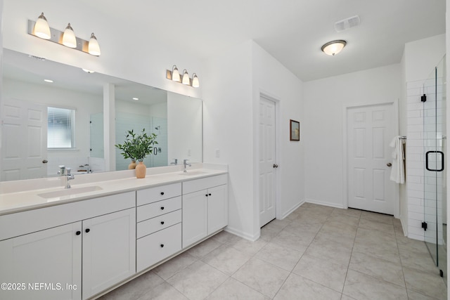 full bathroom with a sink, double vanity, a shower stall, and tile patterned flooring