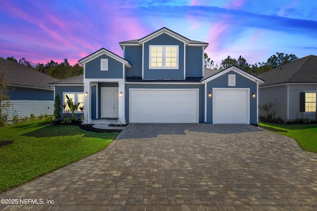 traditional-style home with decorative driveway and a front yard