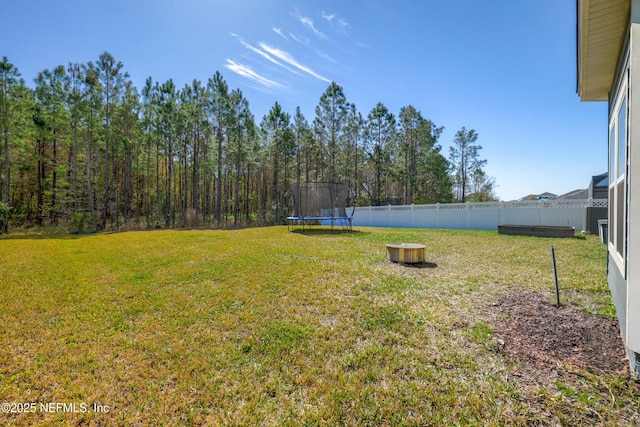 view of yard featuring a trampoline and a fenced backyard