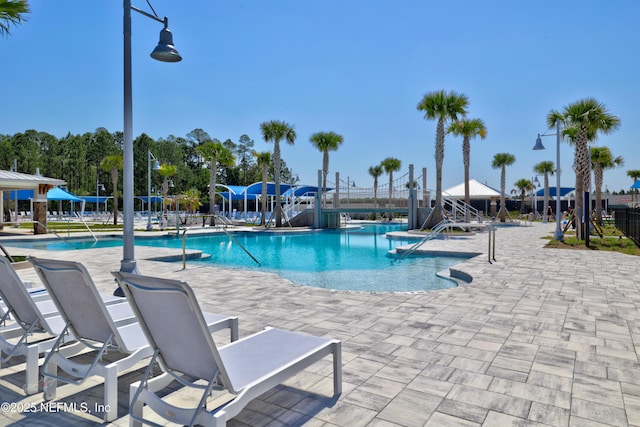 community pool featuring a patio and fence