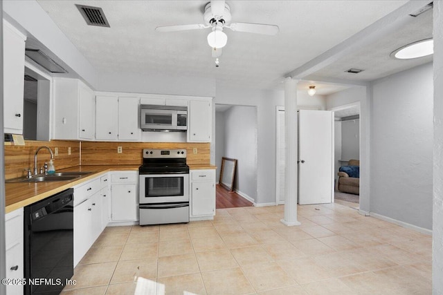 kitchen featuring appliances with stainless steel finishes, sink, white cabinetry, decorative columns, and decorative backsplash