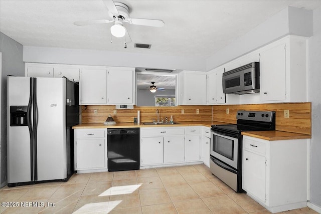 kitchen with appliances with stainless steel finishes, tasteful backsplash, white cabinetry, sink, and ceiling fan