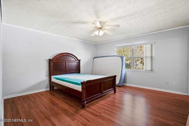 bedroom featuring ceiling fan, dark wood-type flooring, a textured ceiling, and ornamental molding