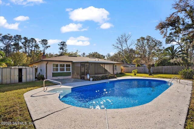 view of pool with a storage unit, a patio, a yard, and a sunroom