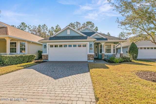 view of front facade with a garage, a front lawn, and covered porch