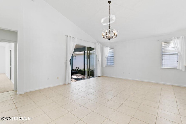 tiled empty room with an inviting chandelier and high vaulted ceiling