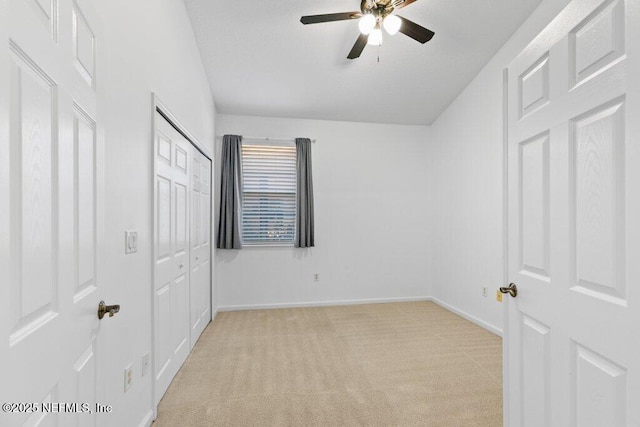 unfurnished bedroom with light colored carpet, ceiling fan, and a closet