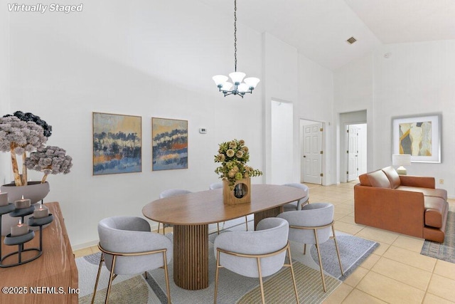 dining room featuring light tile patterned flooring, high vaulted ceiling, and a chandelier