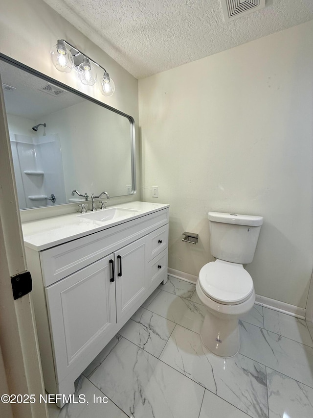 bathroom featuring vanity, a textured ceiling, and toilet