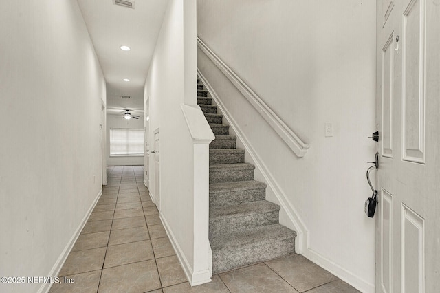 stairway featuring ceiling fan and tile patterned floors