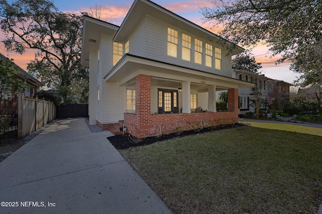 property exterior at dusk featuring a lawn