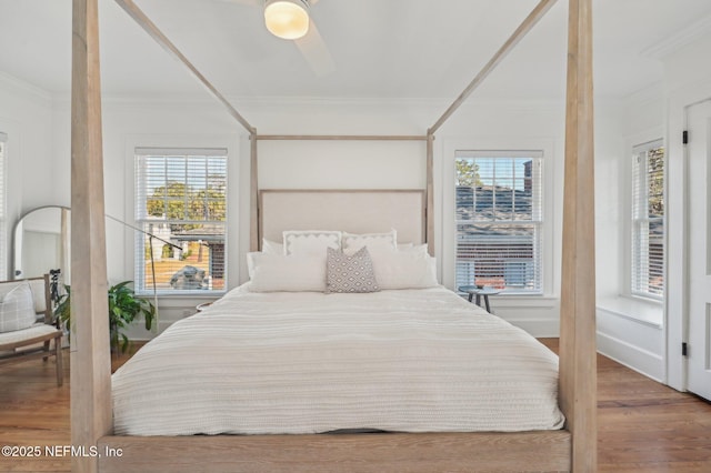 bedroom featuring hardwood / wood-style flooring, ornamental molding, and ceiling fan