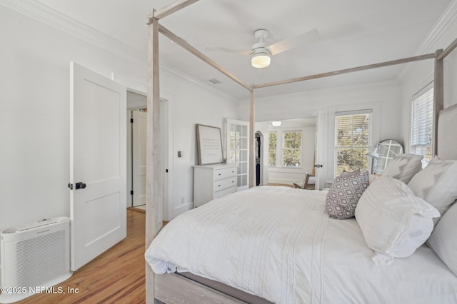 bedroom with crown molding, ceiling fan, and light wood-type flooring