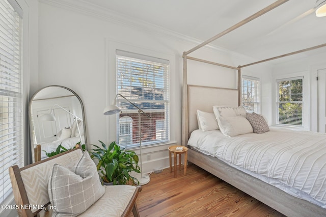 bedroom with crown molding and hardwood / wood-style flooring