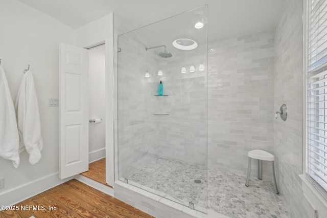 bathroom featuring hardwood / wood-style flooring and tiled shower