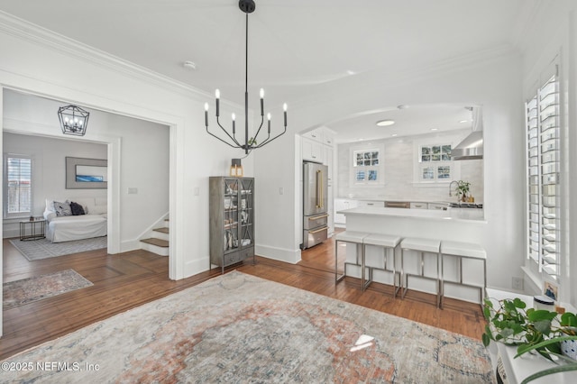 dining area featuring dark hardwood / wood-style flooring, a notable chandelier, and crown molding