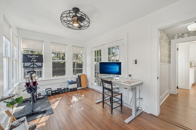 office with hardwood / wood-style flooring and french doors