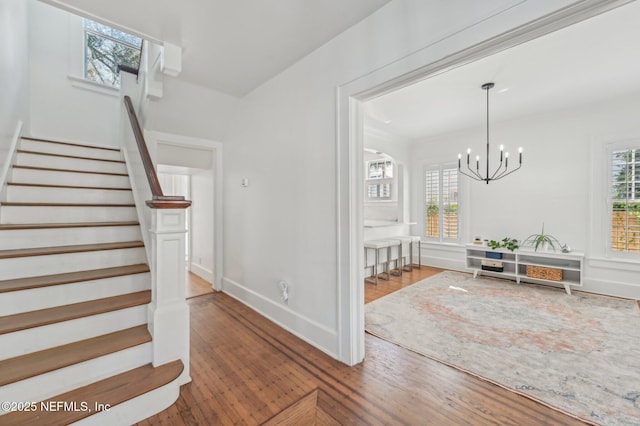 foyer with wood-type flooring and an inviting chandelier