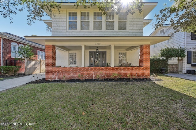 view of front facade featuring covered porch and a front lawn