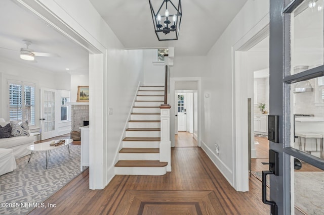 entryway with hardwood / wood-style flooring, ceiling fan, and a fireplace