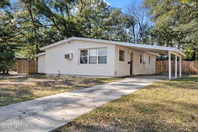 ranch-style house with a front yard, a wall mounted AC, and a carport