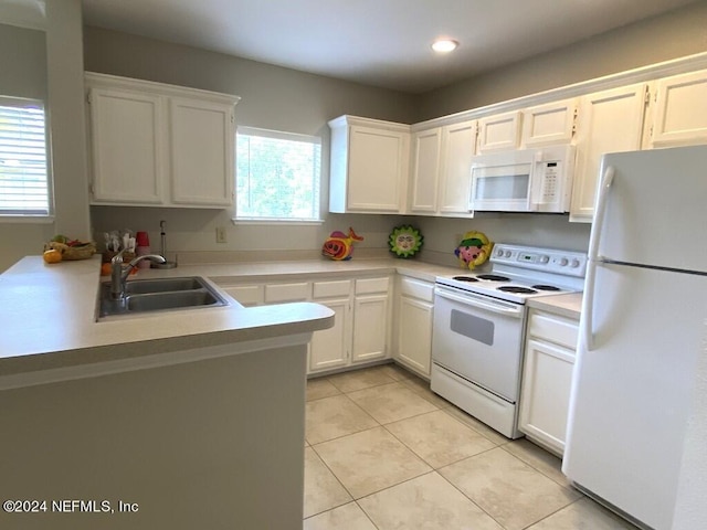 kitchen with white cabinetry, sink, light tile patterned floors, kitchen peninsula, and white appliances