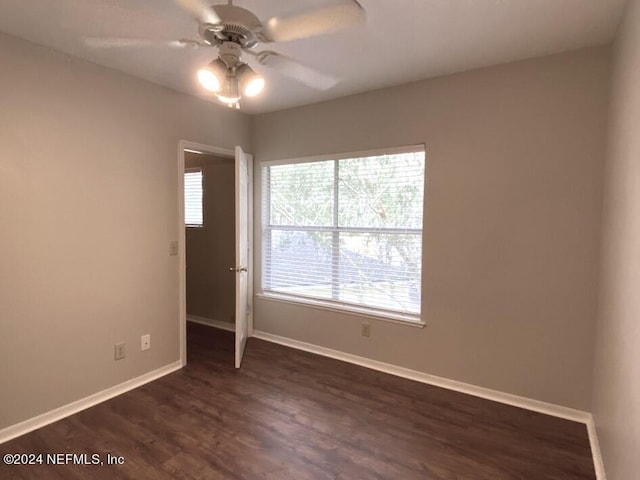 spare room with dark wood-type flooring and ceiling fan