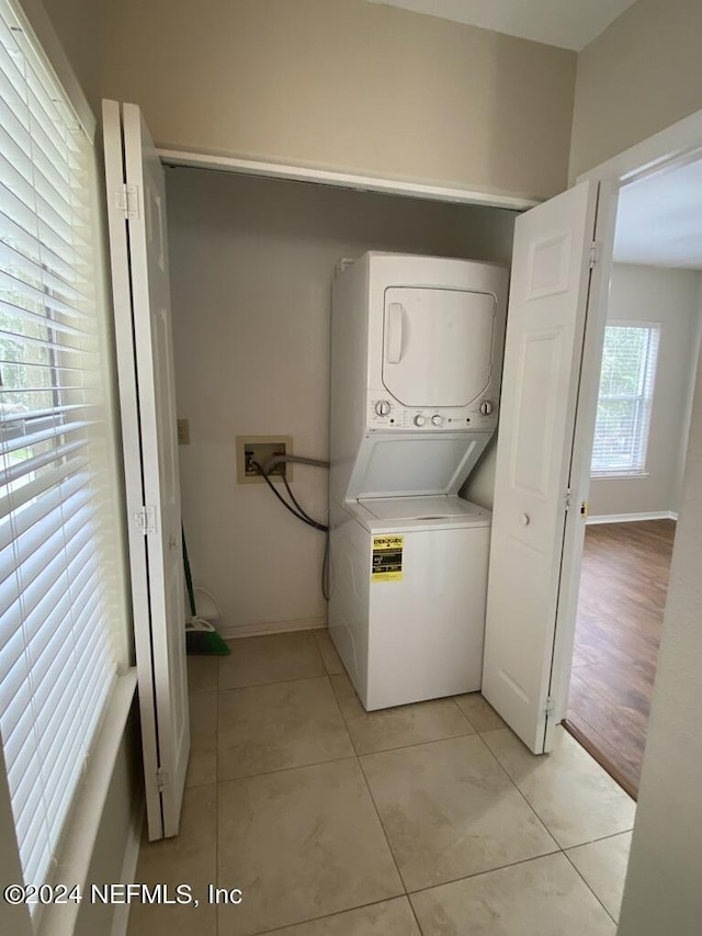 washroom featuring light tile patterned floors and stacked washer and clothes dryer