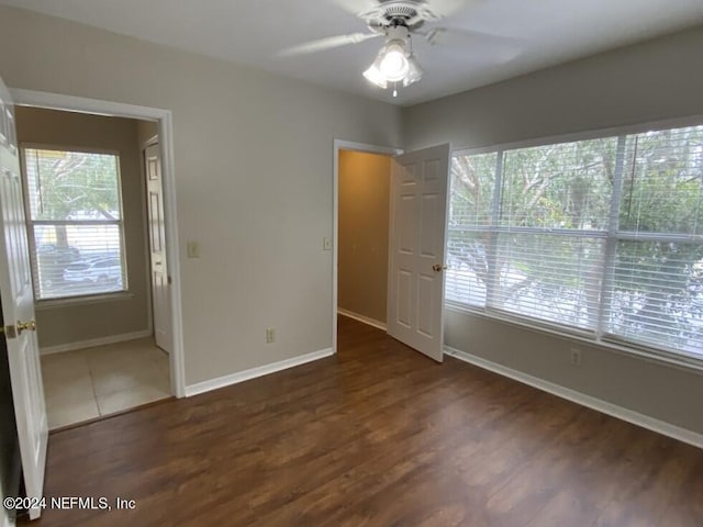 unfurnished room with dark wood-type flooring, plenty of natural light, and ceiling fan