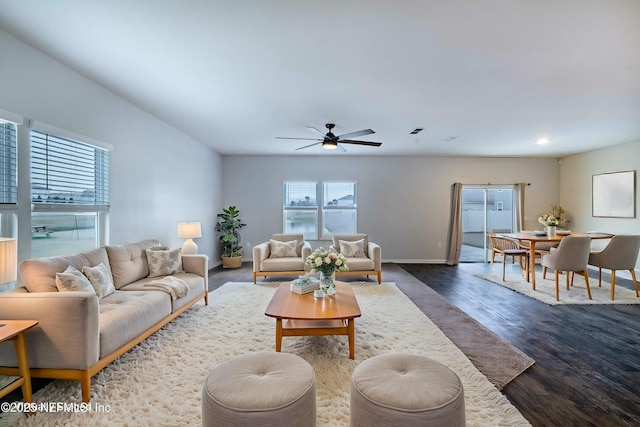 living room featuring dark wood-type flooring and ceiling fan