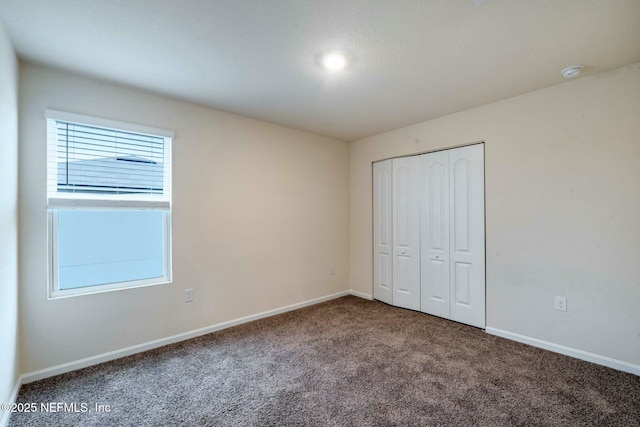 unfurnished bedroom with carpet floors and a closet