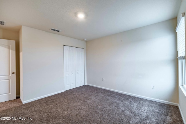 unfurnished bedroom with a closet and carpet flooring