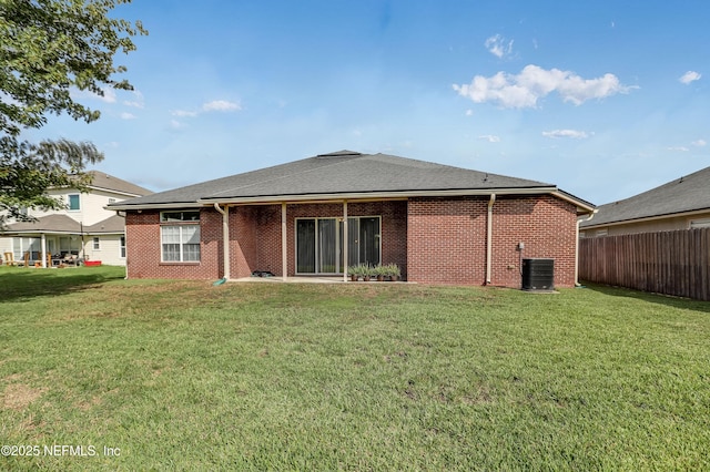 rear view of property featuring central AC unit and a yard