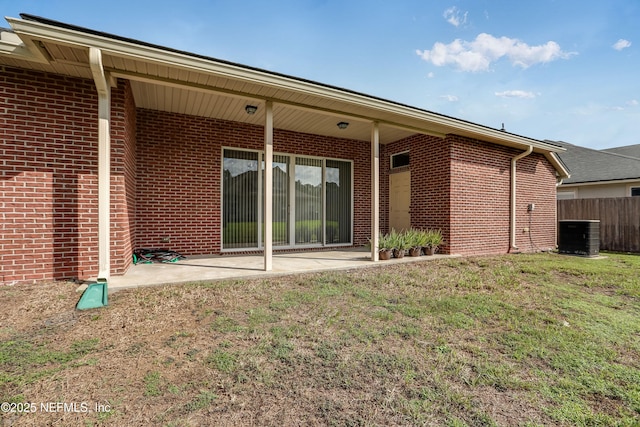 rear view of property featuring cooling unit, a yard, and a patio area