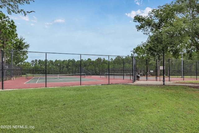 view of tennis court with a yard