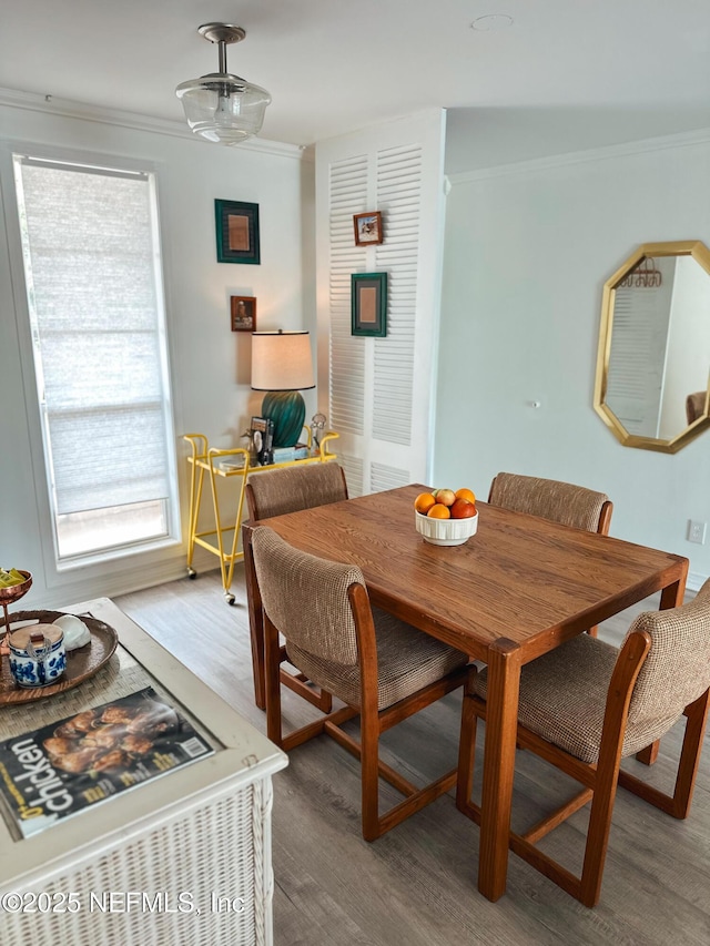 dining space featuring hardwood / wood-style flooring and crown molding