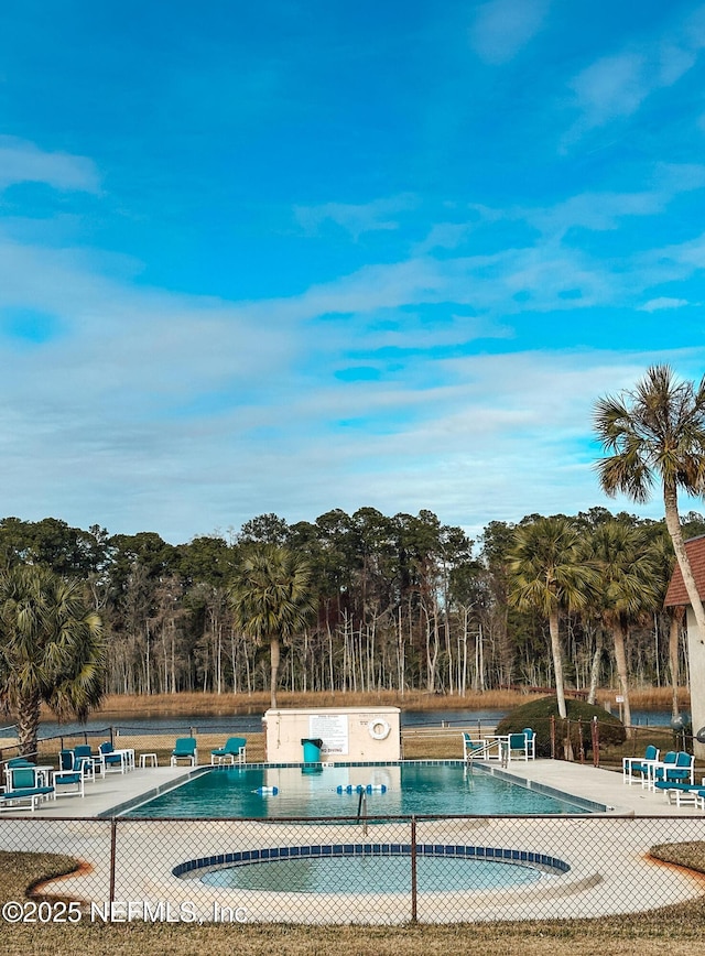 view of swimming pool featuring a hot tub