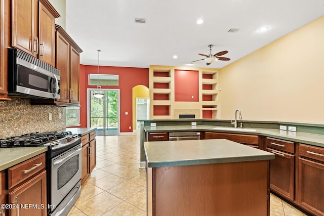 kitchen featuring a center island, sink, decorative light fixtures, stainless steel appliances, and light tile patterned flooring