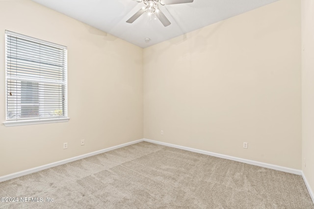 empty room with ceiling fan and light carpet