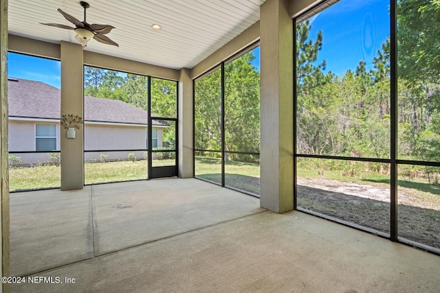 unfurnished sunroom featuring ceiling fan and a wealth of natural light