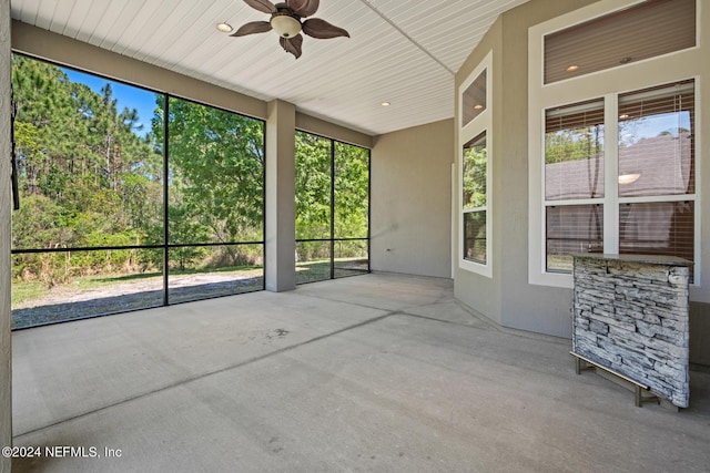 unfurnished sunroom with ceiling fan