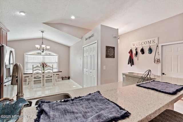 kitchen with stainless steel fridge with ice dispenser, decorative light fixtures, a textured ceiling, and lofted ceiling