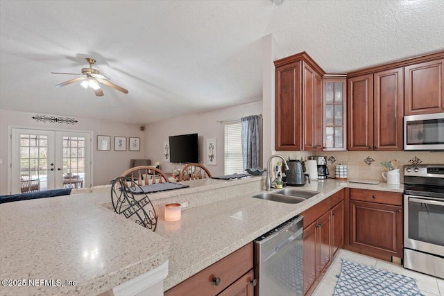 kitchen featuring a textured ceiling, light tile patterned floors, sink, french doors, and stainless steel appliances